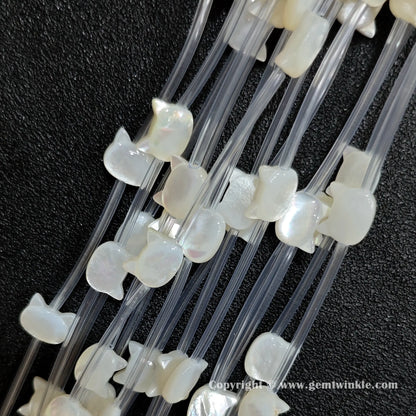 Multiple strands of white mop kitty silhouette beads displaying pearl sheen
