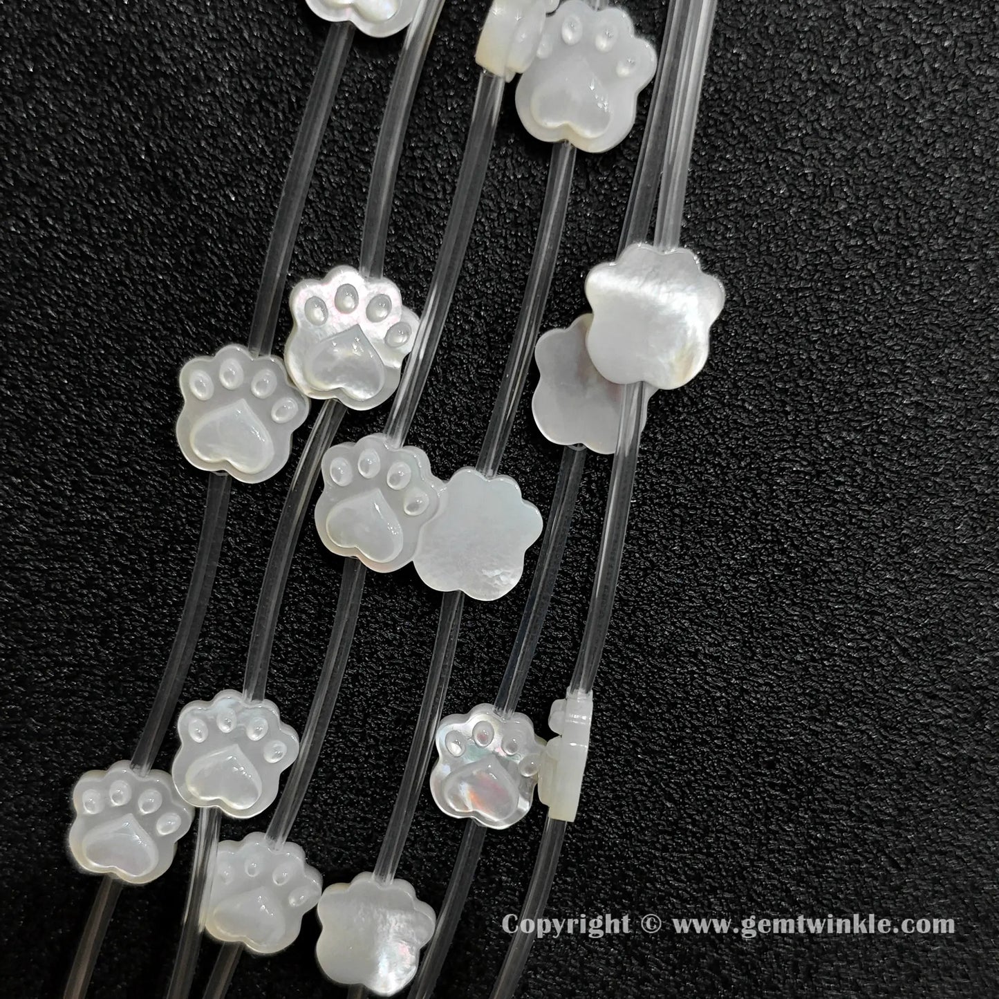 Multiple strands of white mop pet paw beads displaying pearly luster