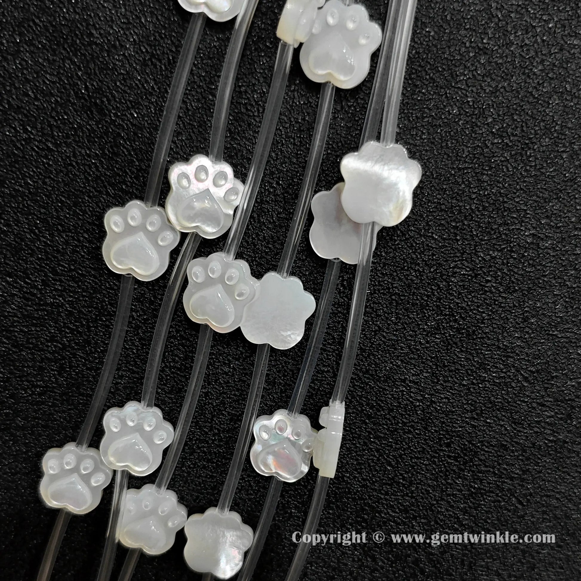 Multiple strands of white mop pet paw beads displaying pearly luster