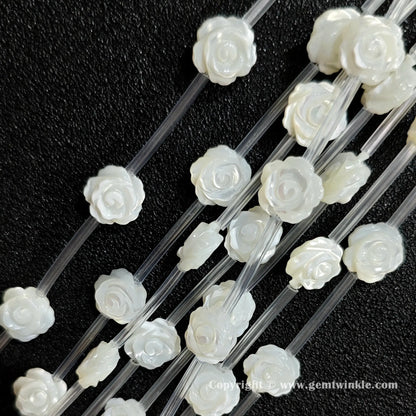 Multiple strands of white mother of pearl rose carving beads displaying pearlescent shine