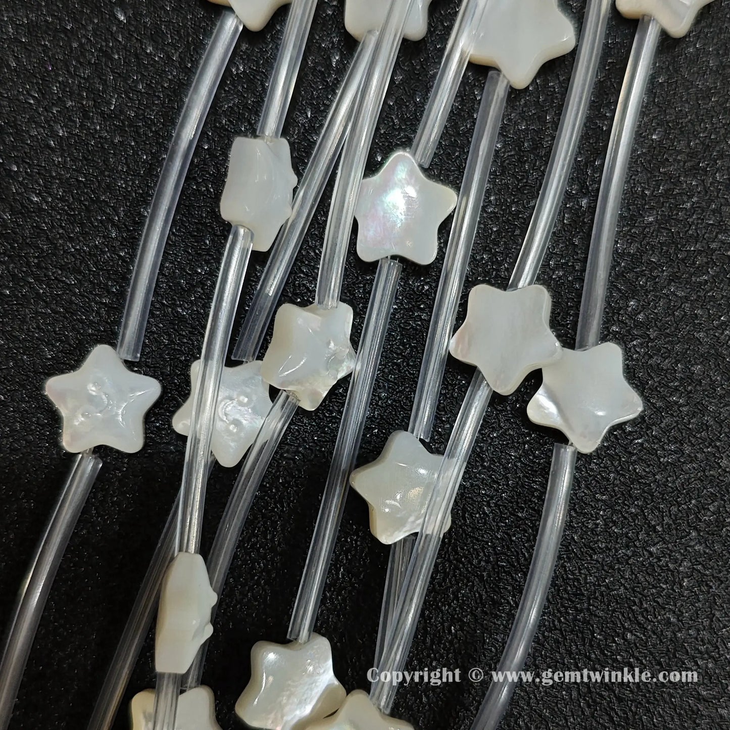 Multiple strands of white mop smiling star beads with pearlescent luster