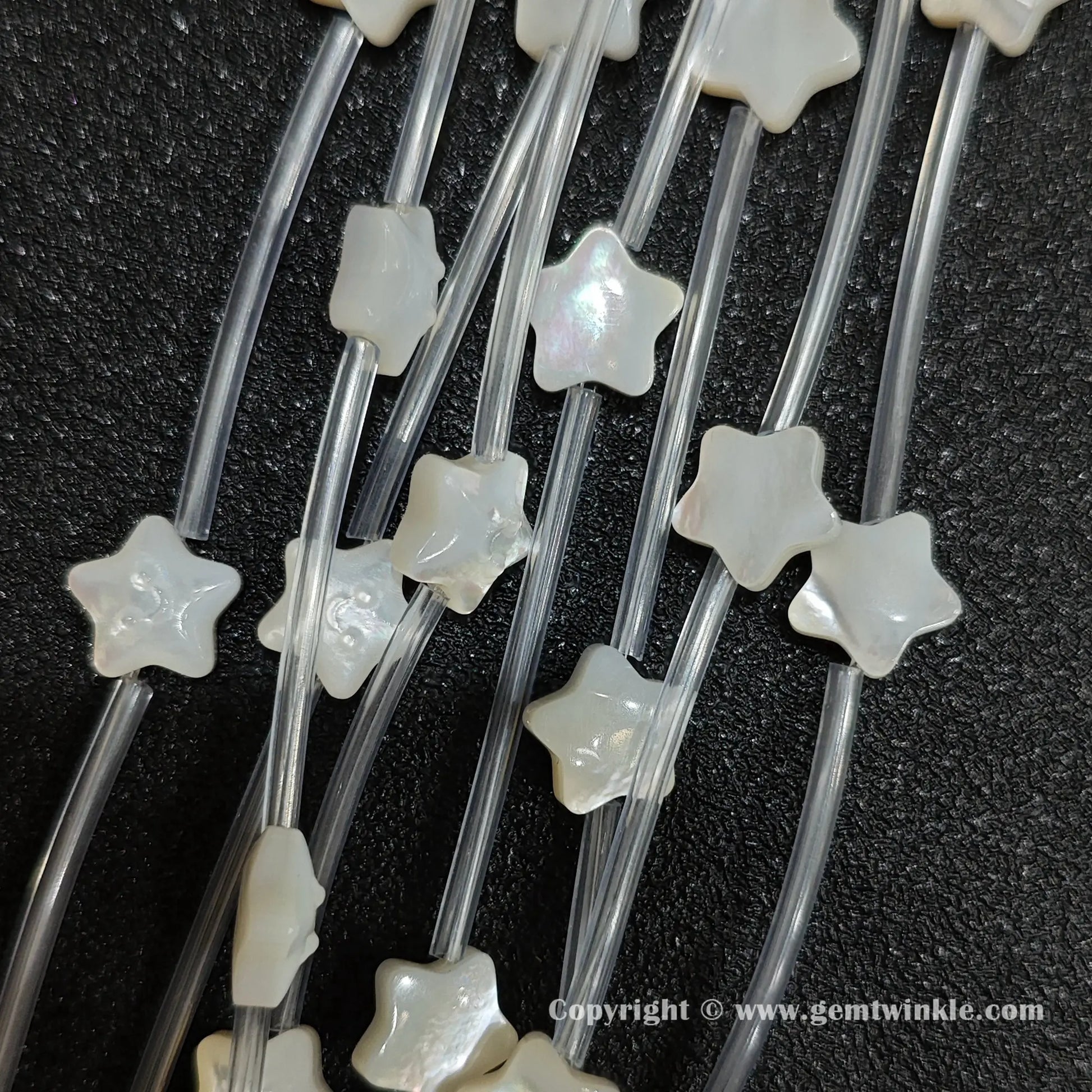 Multiple strands of white mop smiling star beads with pearlescent luster