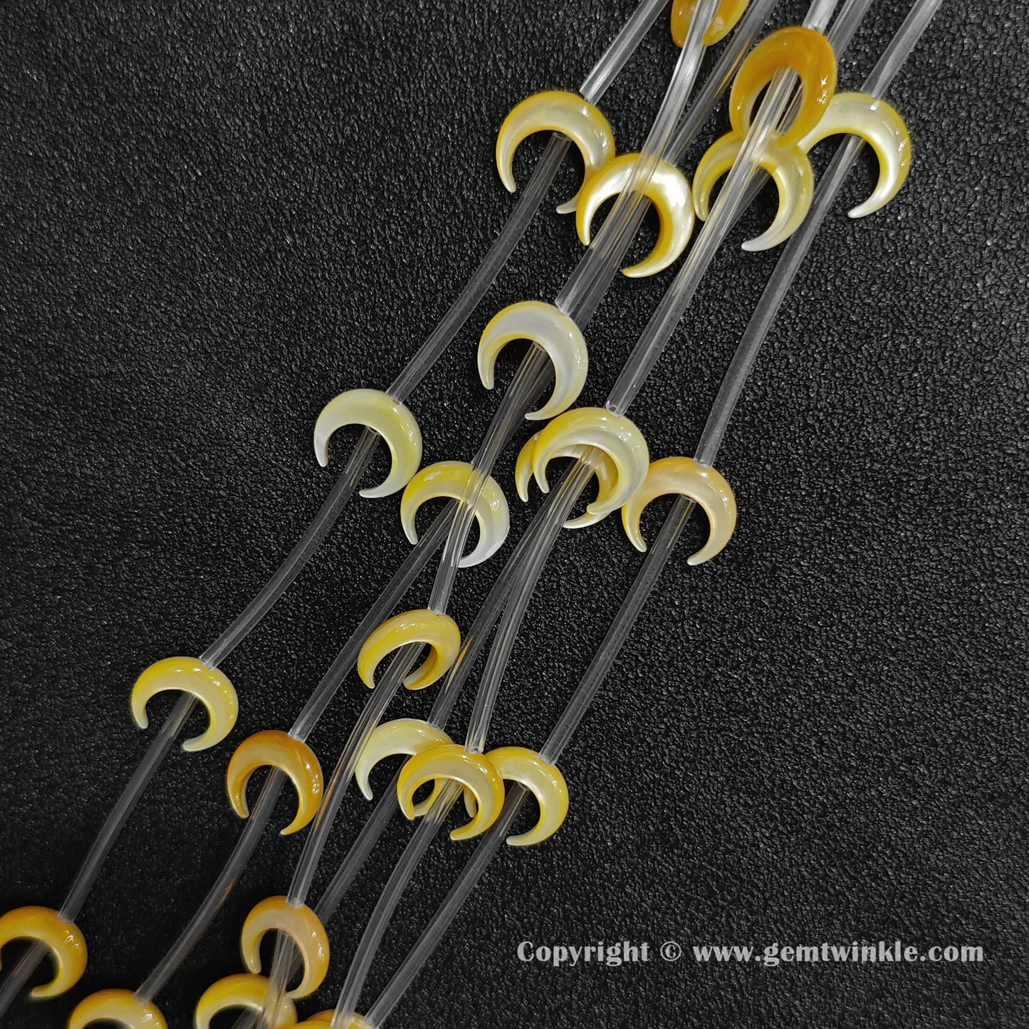 Multiple strands of yellow mop crescent moon beads with warm golden luster