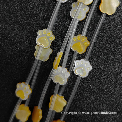 Multiple strands of yellow shell cat paw beads displaying warm golden luster