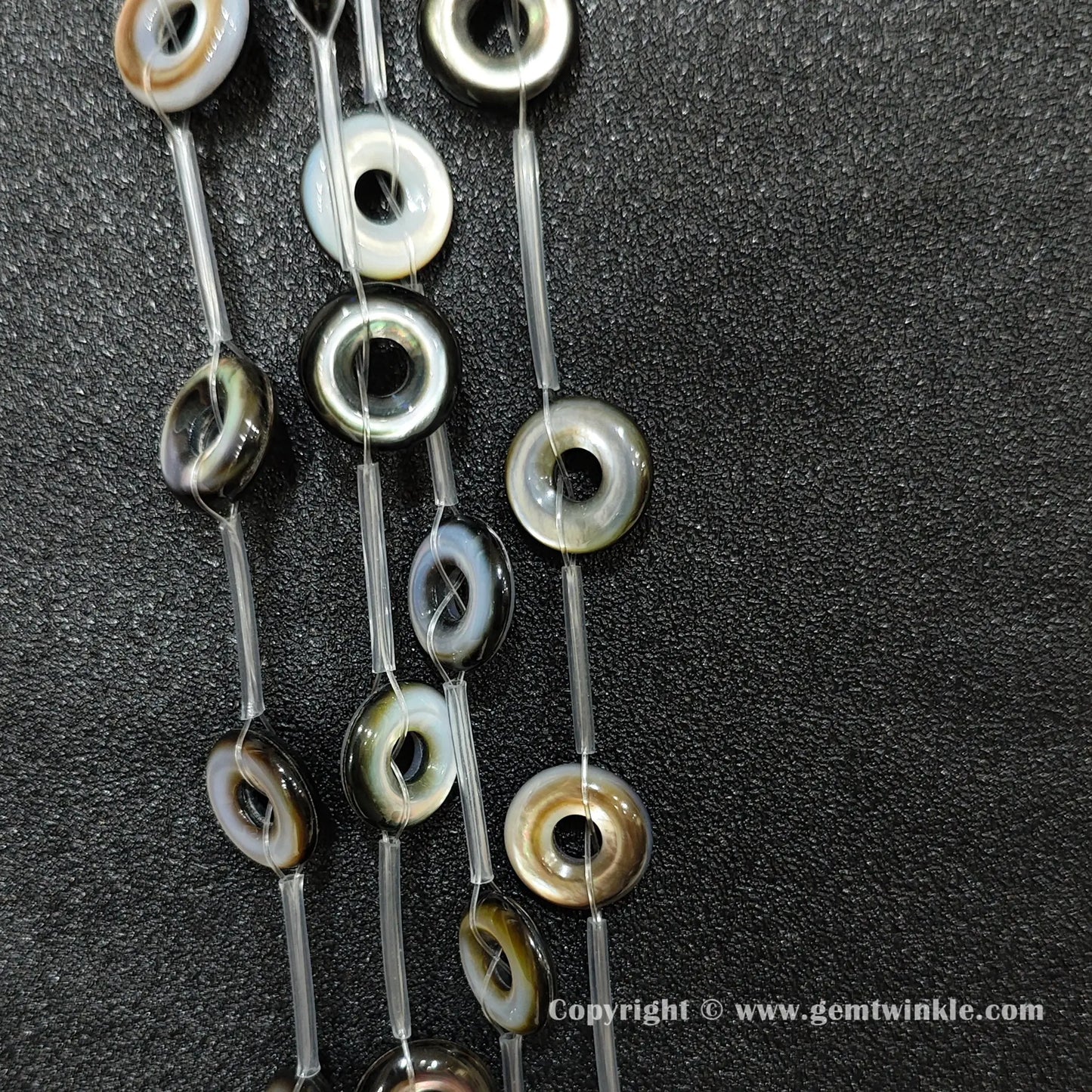 strands of layered black shell donut beads with rainbow luster