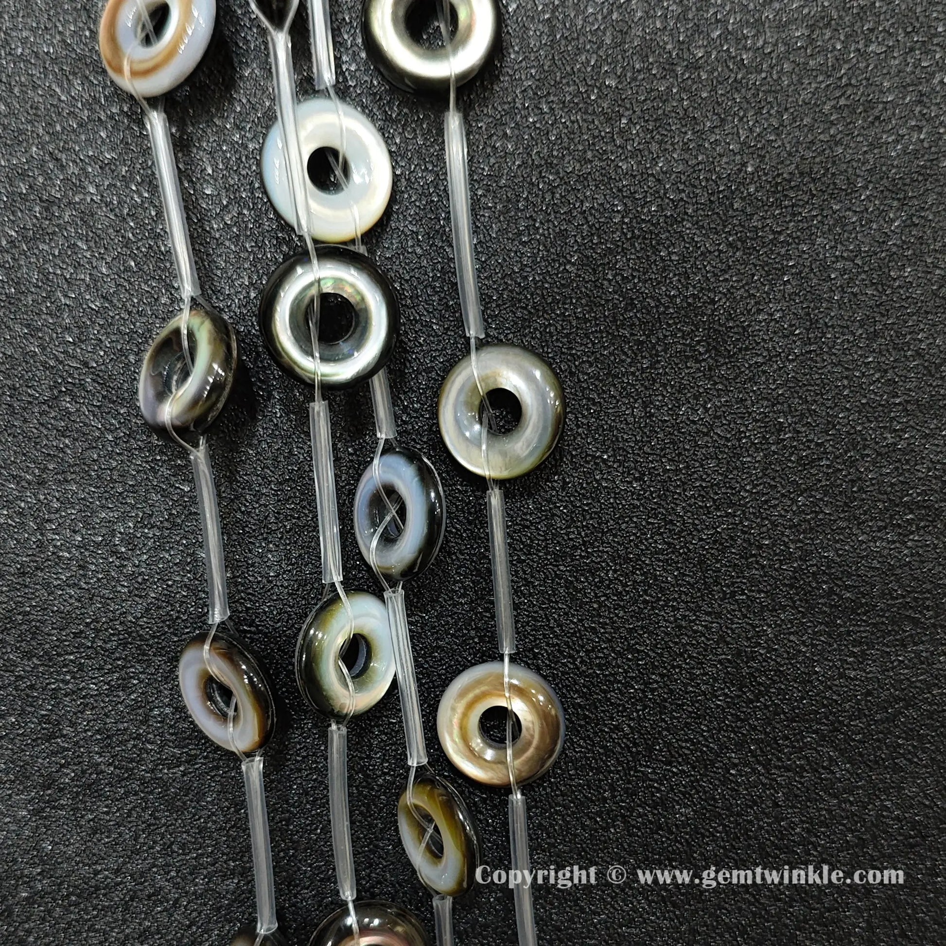 strands of layered black shell donut beads with rainbow luster