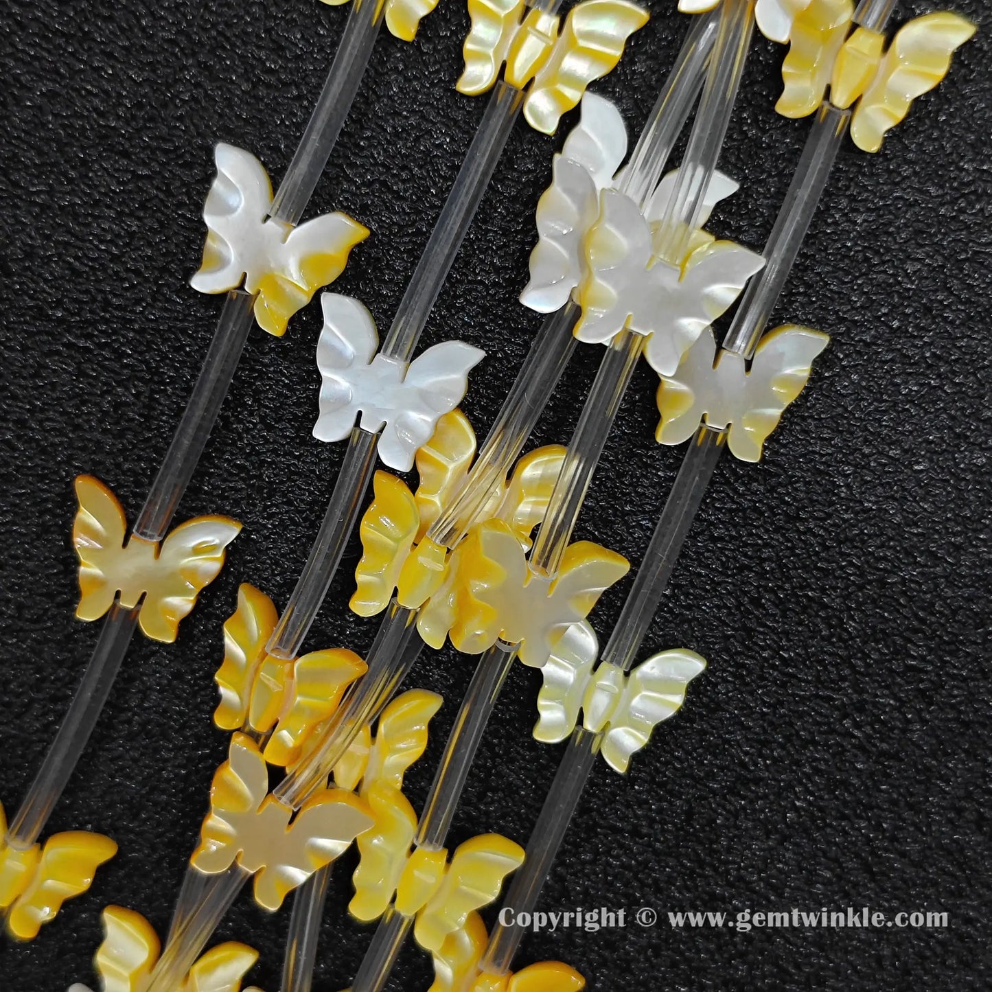 strands of yellow mop carved butterfly beads with iridescent luster