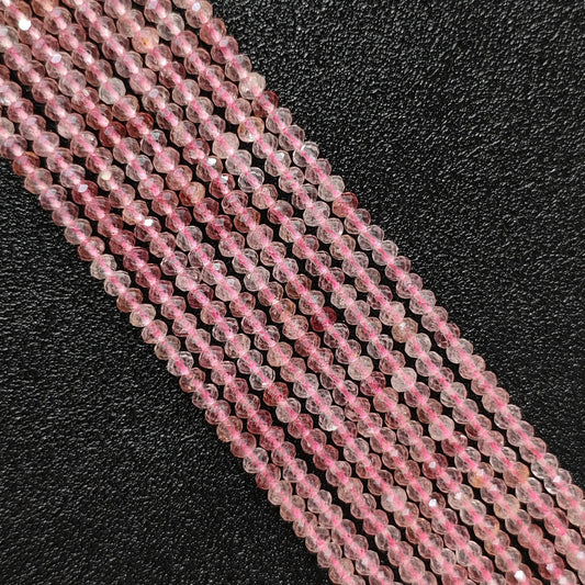 Macro closeup of strawberry quartz faceted rondelle beads showing pink tone and internal inclusions