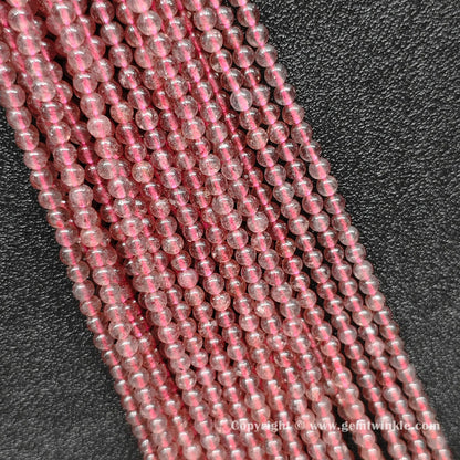 Multiple parallel strawberry quartz round bead strands showing soft pink color