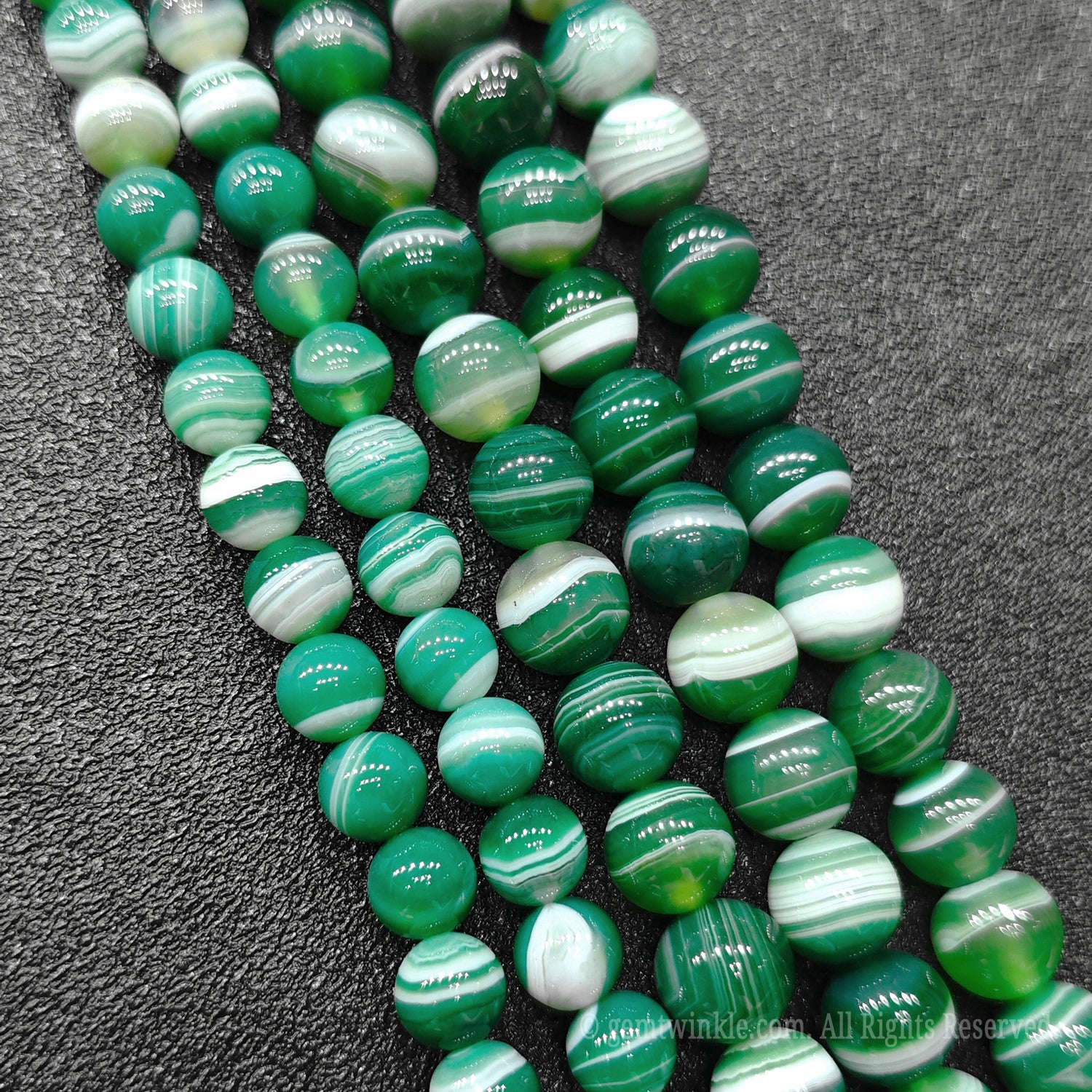 Four strands of vibrant green striped agate loose crystal beads highlighting high polish spherical finish direct from donghai market