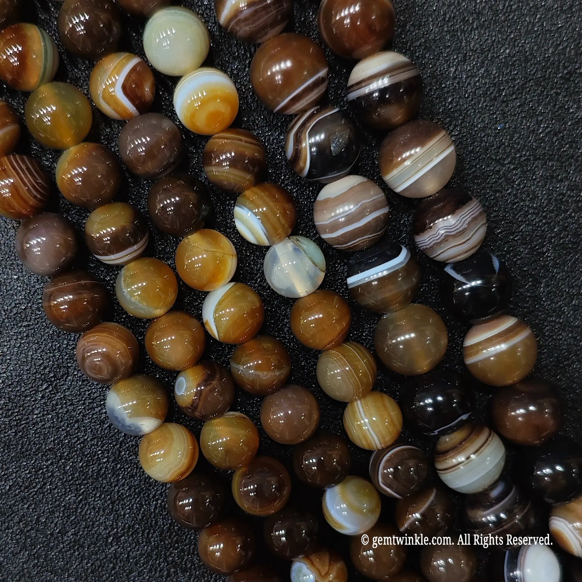 supplies for bead making jewelry displaying standard grade high polish coffee colored striped agate round strands with minor natural variations