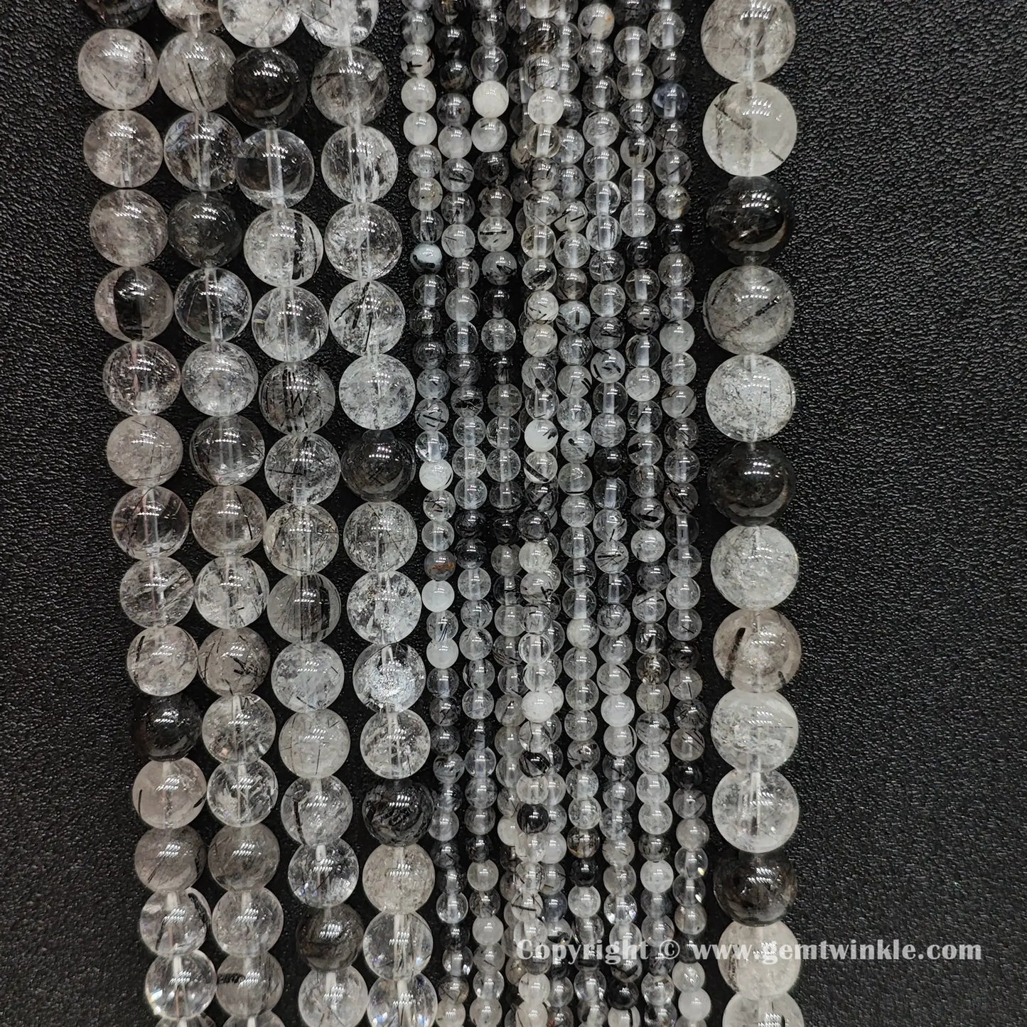 Bulk display of un-dyed commercial B grade black tourmaline rutilated quartz bead strands perfect for handmade bracelet and necklace designs