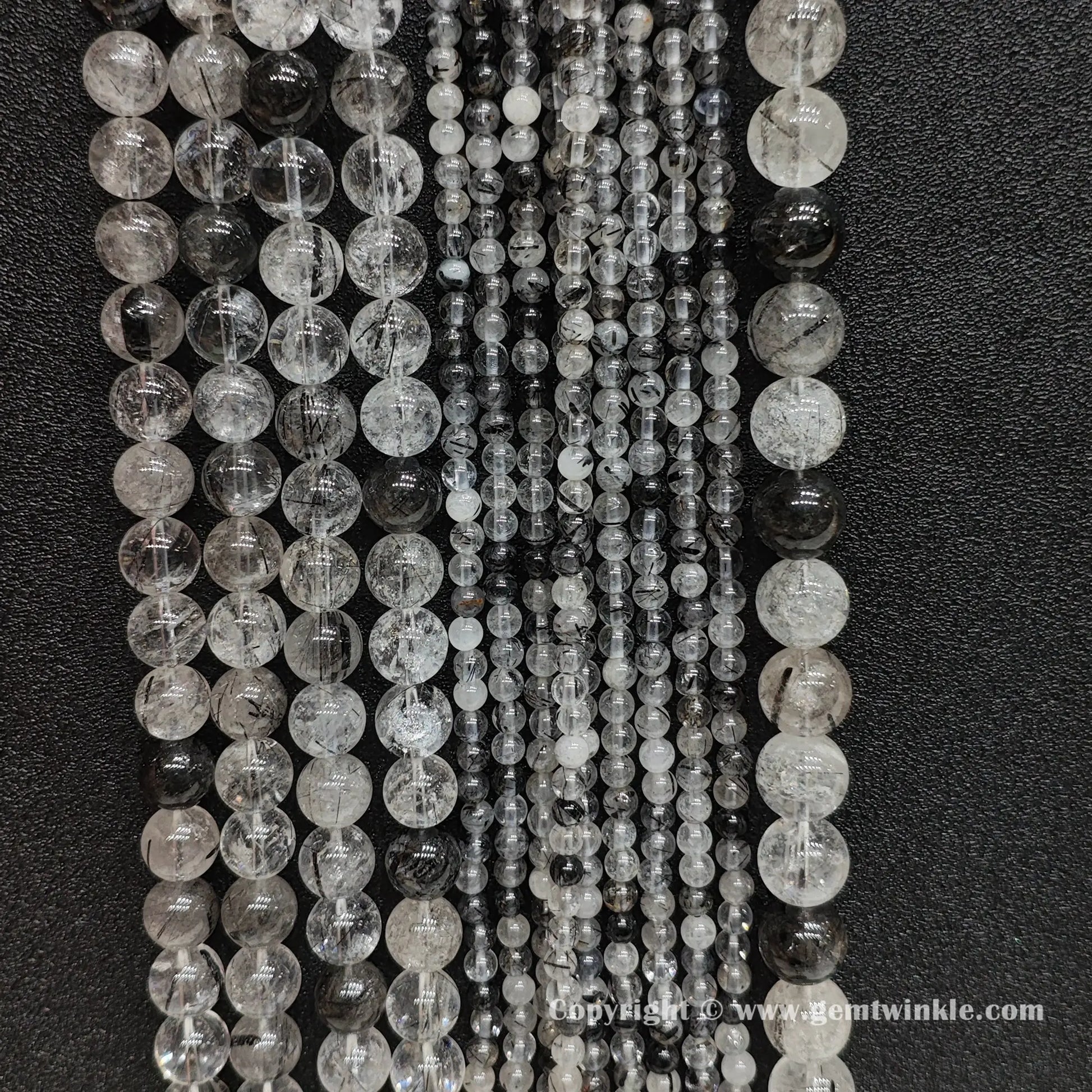 Bulk display of un-dyed commercial B grade black tourmaline rutilated quartz bead strands perfect for handmade bracelet and necklace designs