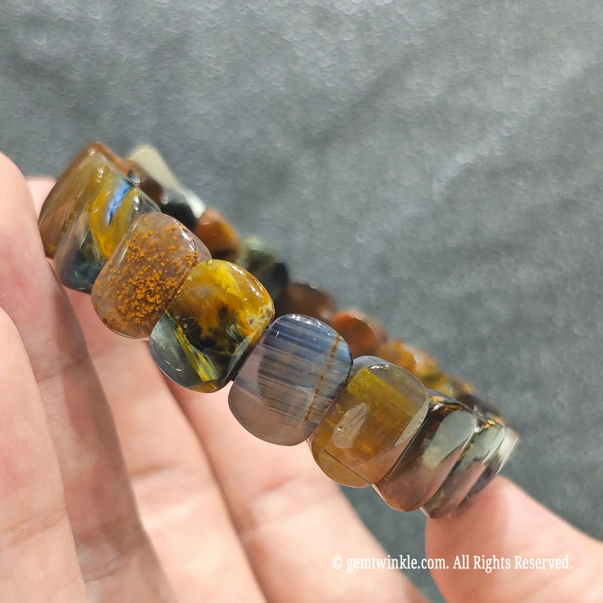 Side view of a swirling pietersite rectangle stretch wristlet displaying brecciated silky chatoyant fragments[cite: 6]
