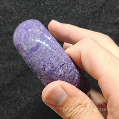 side view showing natural fibrous violet texture of charoite bangle