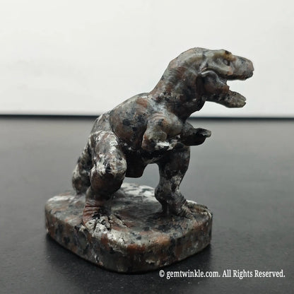 right side perspective view of carved t-rex dinosaur statue under daylight displaying base details and stone grain