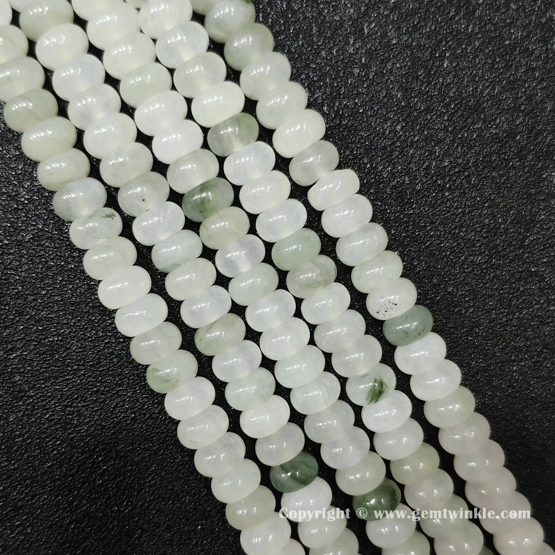 Perspective view of tianshan jade smooth heishi spacer beads showing uniform 4mm disc thickness