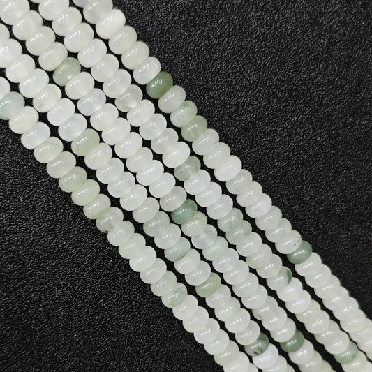 Macro closeup of natural tianshan jade smooth rondelle beads 6x4mm showing icy white and green matrix