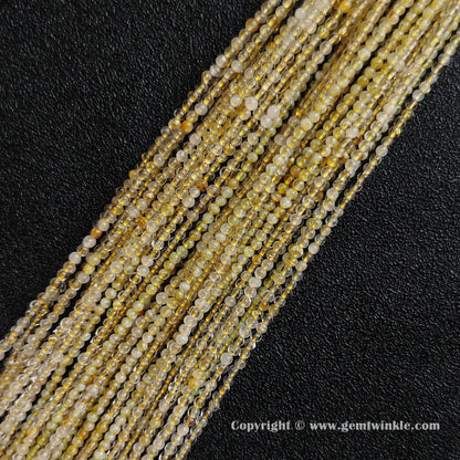 Multiple tiny crystal strands of genuine B minus grade 2mm gold hair quartz beads displaying heavy white internal cloud inclusions from factory supplier