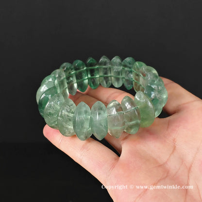 Flat display of translucent fluorite geometric cuff bracelet highlighting inner wisps and cleavages