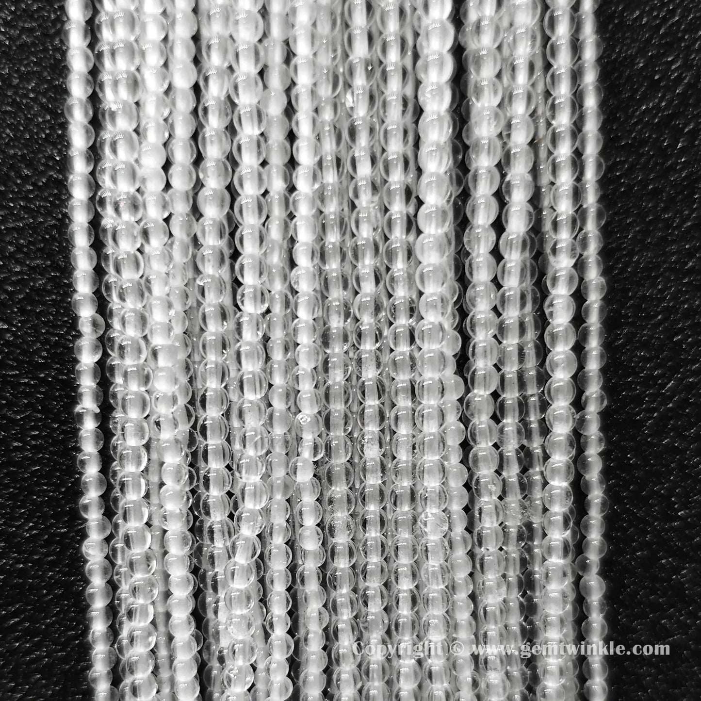 Perspective view of translucent clear quartz loose round beads showing smooth micro polish