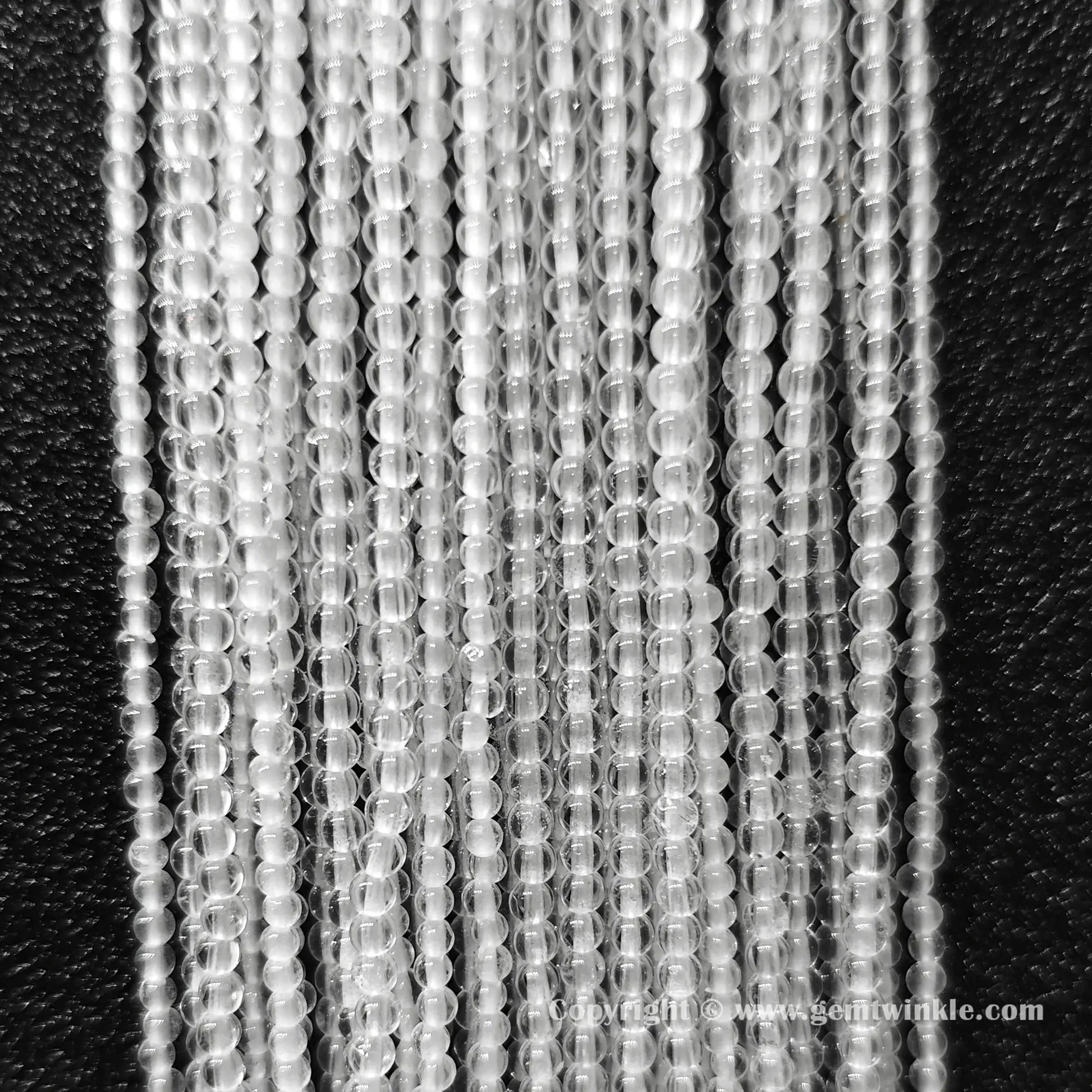 Perspective view of translucent clear quartz loose round beads showing smooth micro polish