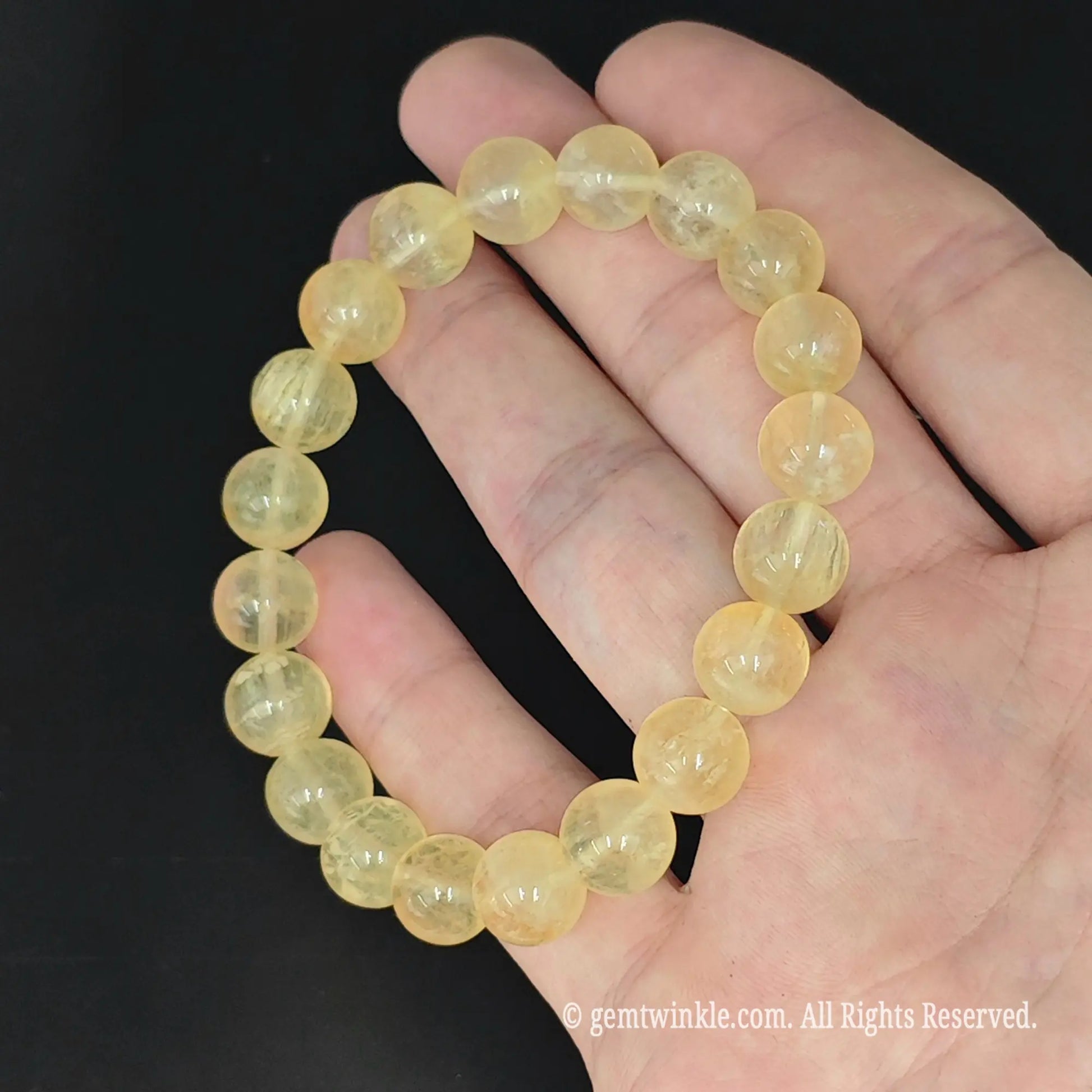top view of translucent yellow fluorite round bead stretch bangle on hand