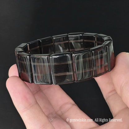 Side view of translucent ice obsidian curved plate cuff bracelet highlighting polished plate thickness and visible dual cord
