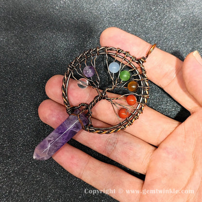 Hand holding 8cm amethyst crystal point pendant wrapped in antique copper metal alloy wire