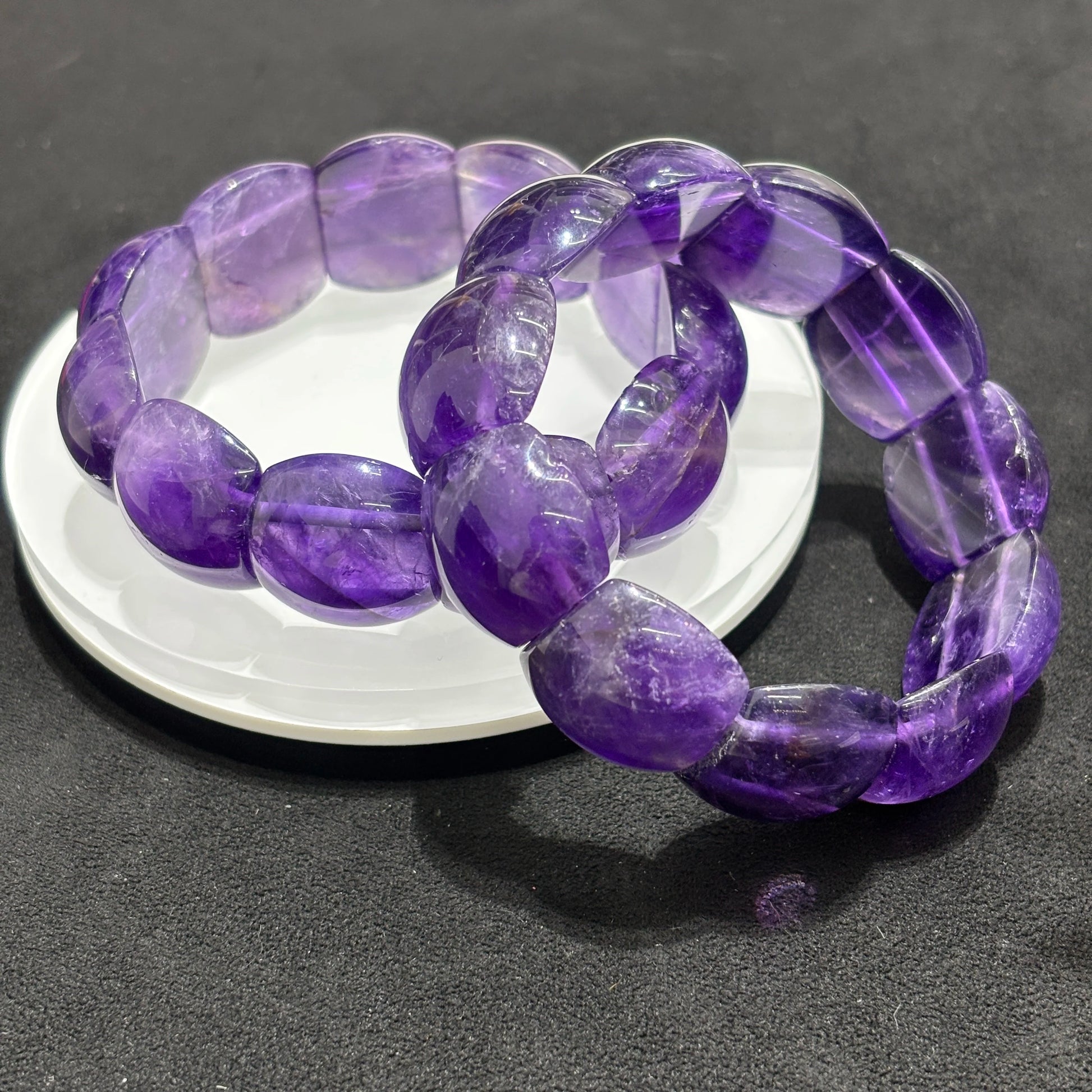 two-natural-amethyst-bangle-bracelets-on-dish