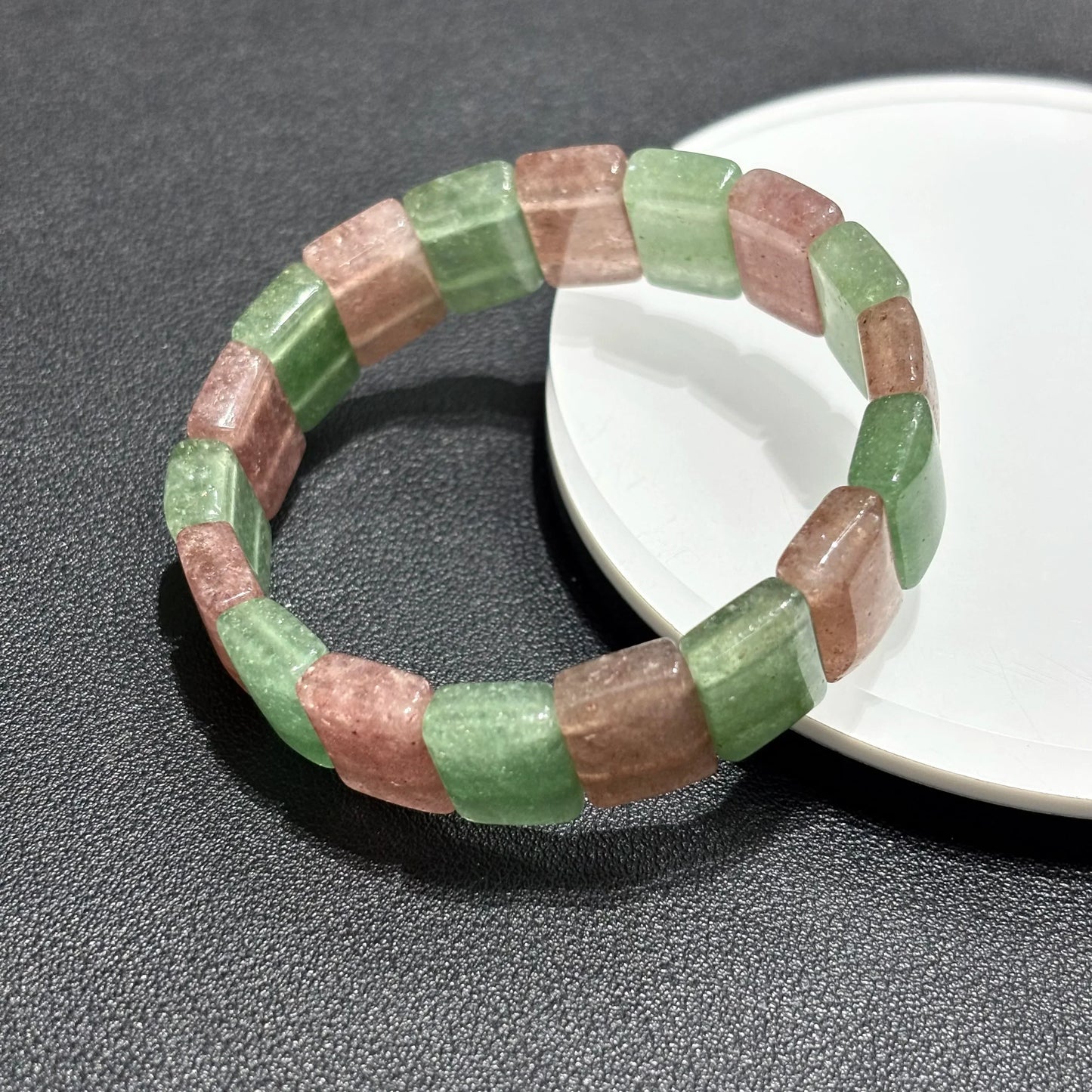 Two Natural Pink & Green Strawberry Quartz Bangle Bracelets arranged on a white plate, showcasing the elastic stretch and bead alignment.