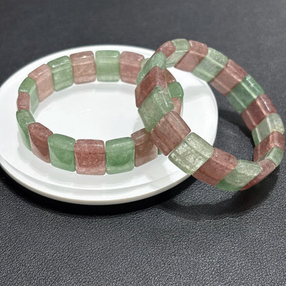 Two Natural Pink & Green Strawberry Quartz Bangle Bracelets displayed on a white plate, showing the color variation and stacking potential.