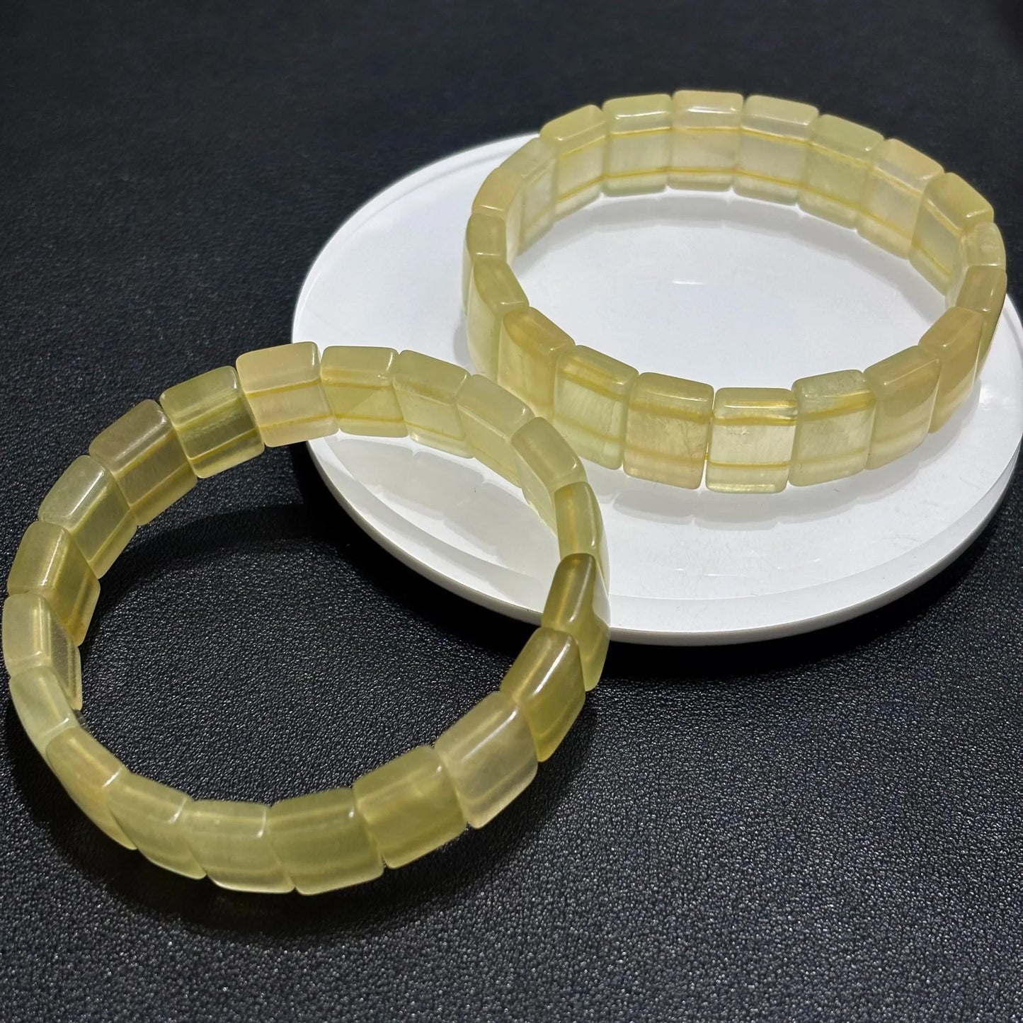 Two Natural Yellow Fluorite Bangle Bracelets stacked on a white plate, demonstrating the stackable design and uniform sizing.