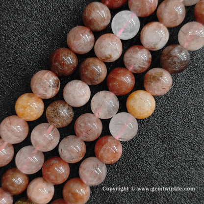 Three strands of un-dyed genuine red rutilated quartz round beads displaying organic iron inclusions and mixed amber tones from factory supplier