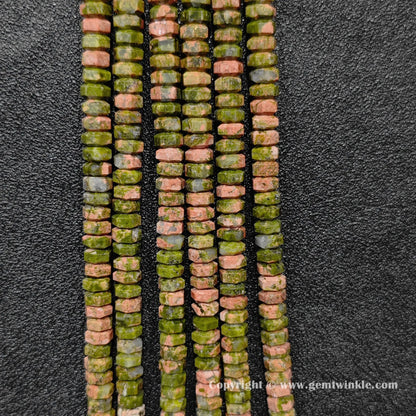 Perspective view of unakite faceted heishi spacer beads showing uniform 3mm disc thickness