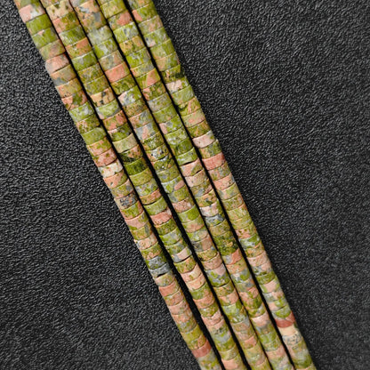Macro closeup of natural unakite heishi rondelle beads 6x3mm showing green and pink mineral matrix