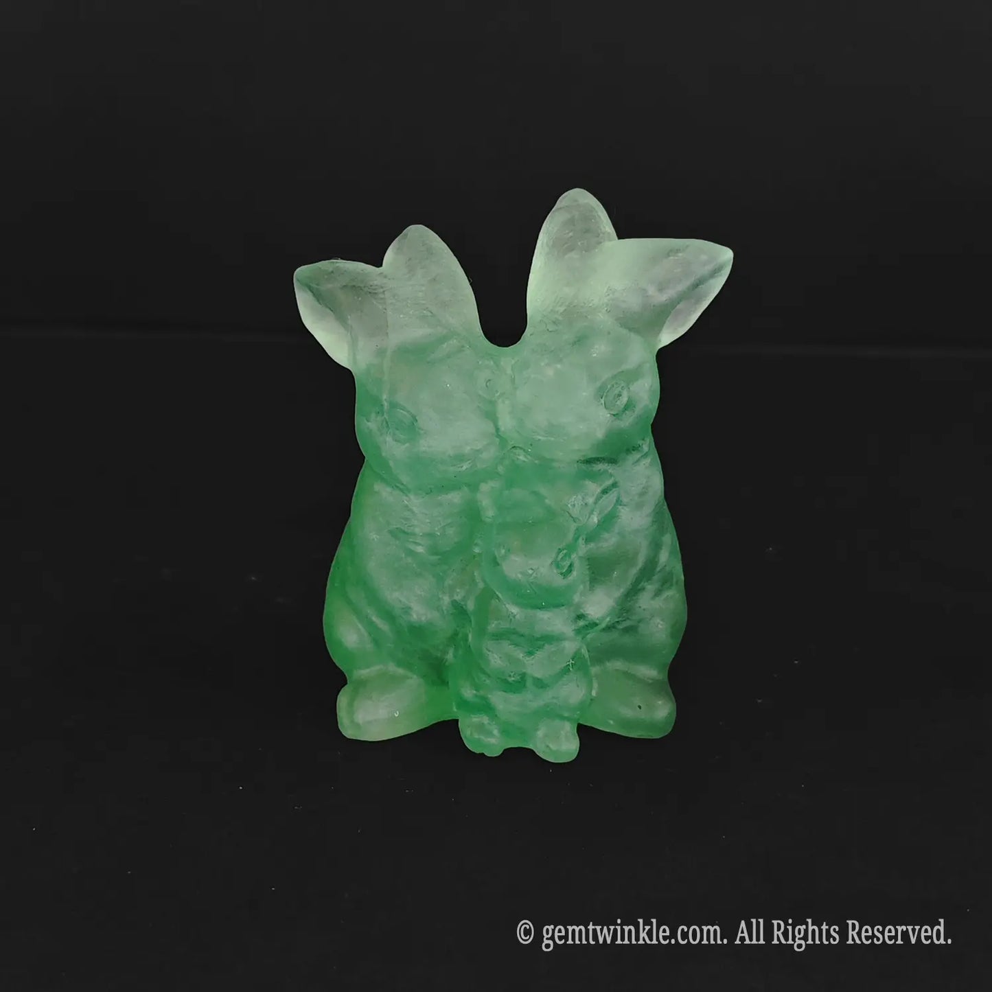 Natural untamed green fluorite rabbit family of three sculpture showing translucent parents sheltering a baby bunny