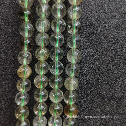 Close up view of untreated green hair crystal beading strands highlighting clear quartz transparency
