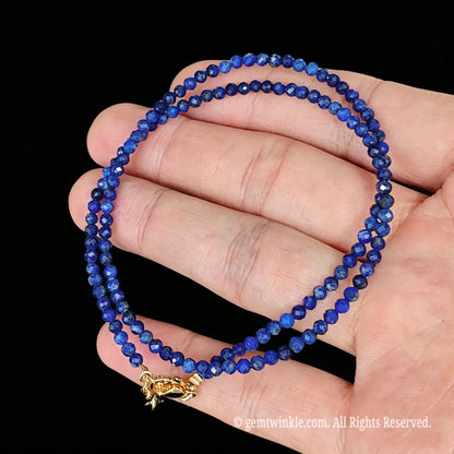 untreated lapis lazuli faceted micro bead necklace loop with gold tone extender chain in hand