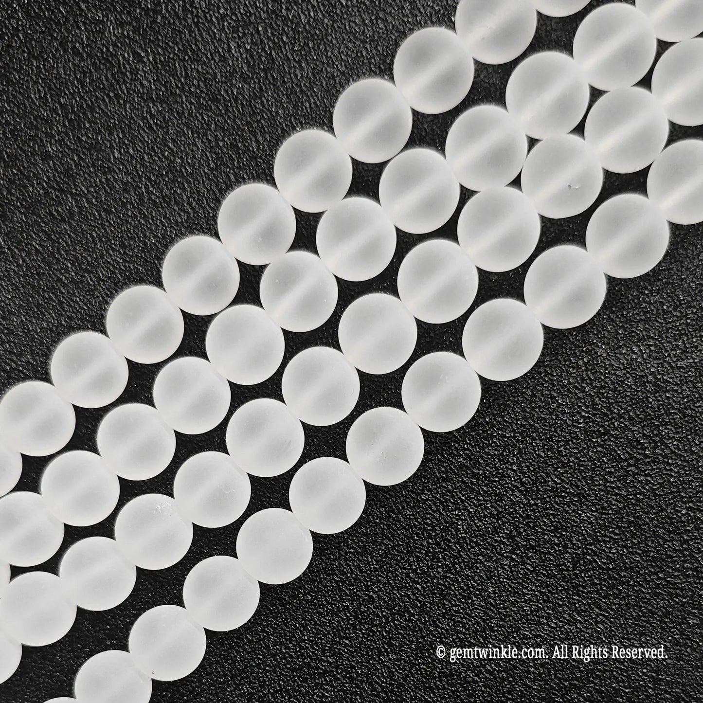 Four parallel strands of natural matte frosted rock crystal quartz beads showing soft white texture