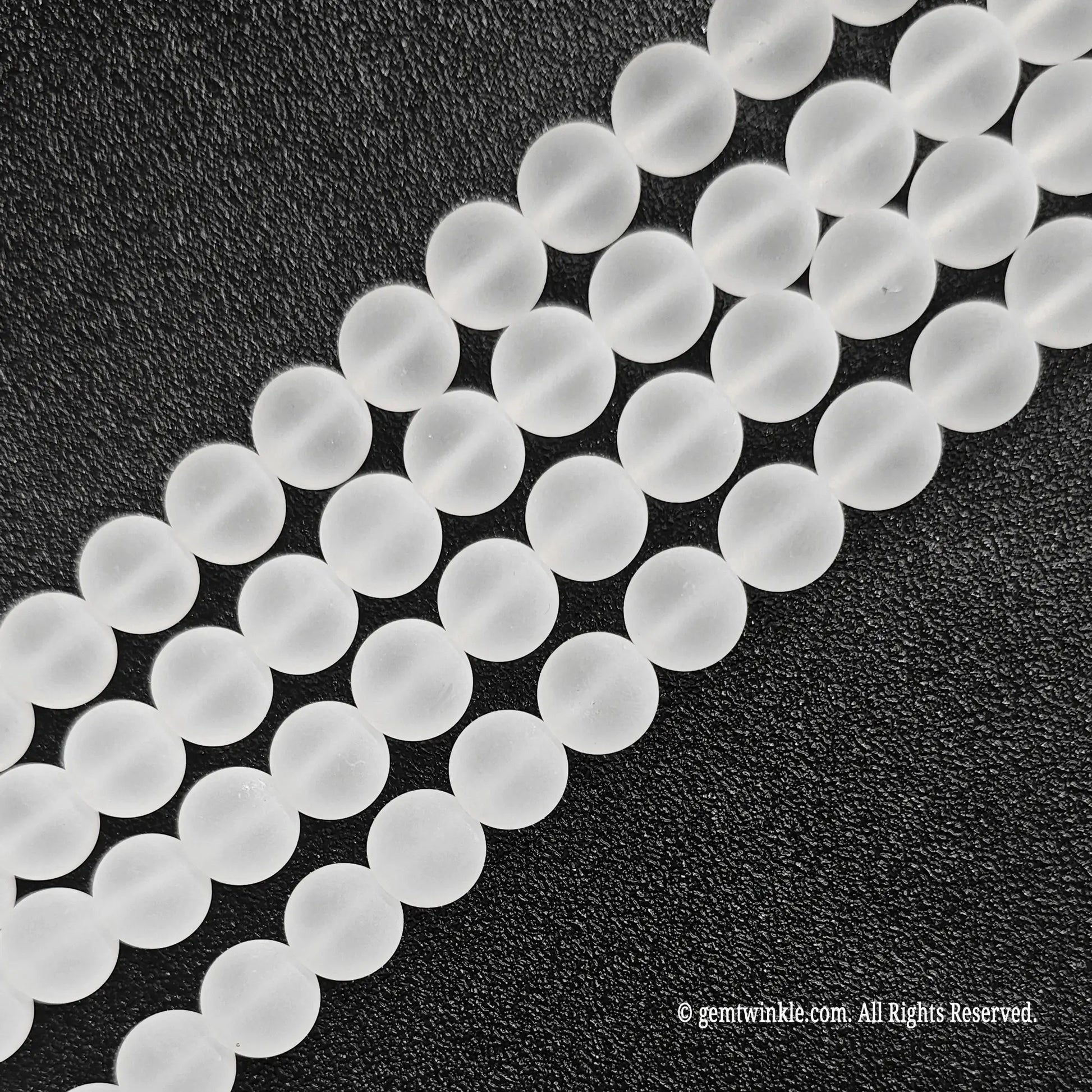 Four parallel strands of natural matte frosted rock crystal quartz beads showing soft white texture