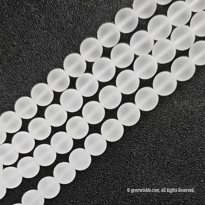 Four parallel strands of natural matte frosted rock crystal quartz beads showing soft white texture