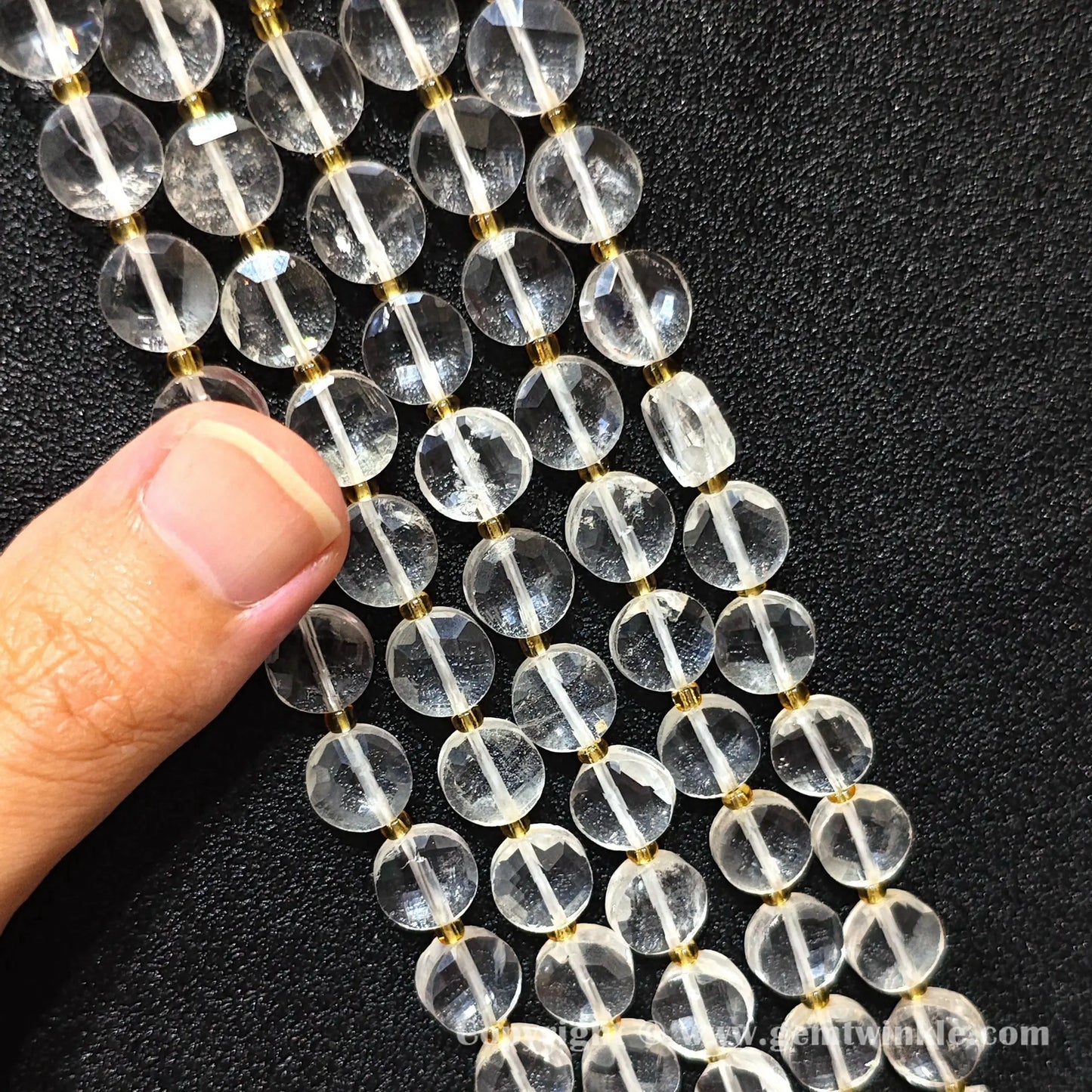 Hand preview showcasing 8mm and 10mm clear rock quartz faceted wheel beads