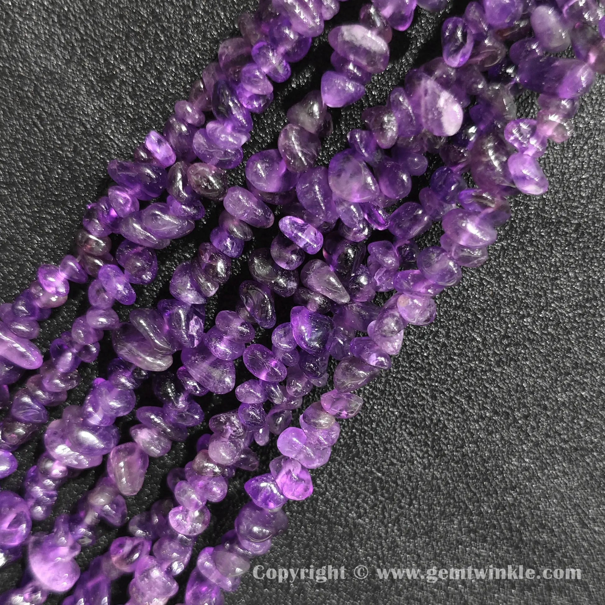 Long strand layout of raw violet amethyst chip beads for jewelry making
