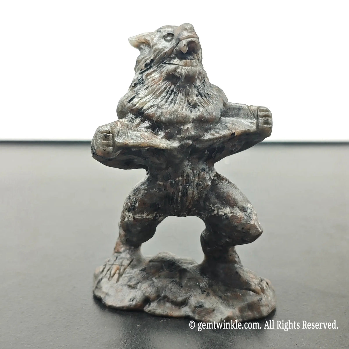 front view of standing werewolf monster statue in roaring stance on integrated stone base under daylight