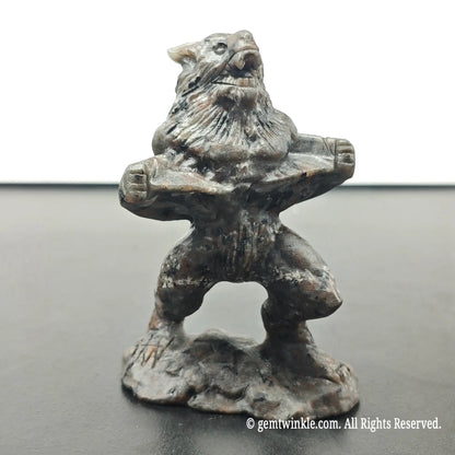 front view of standing werewolf monster statue in roaring stance on integrated stone base under daylight