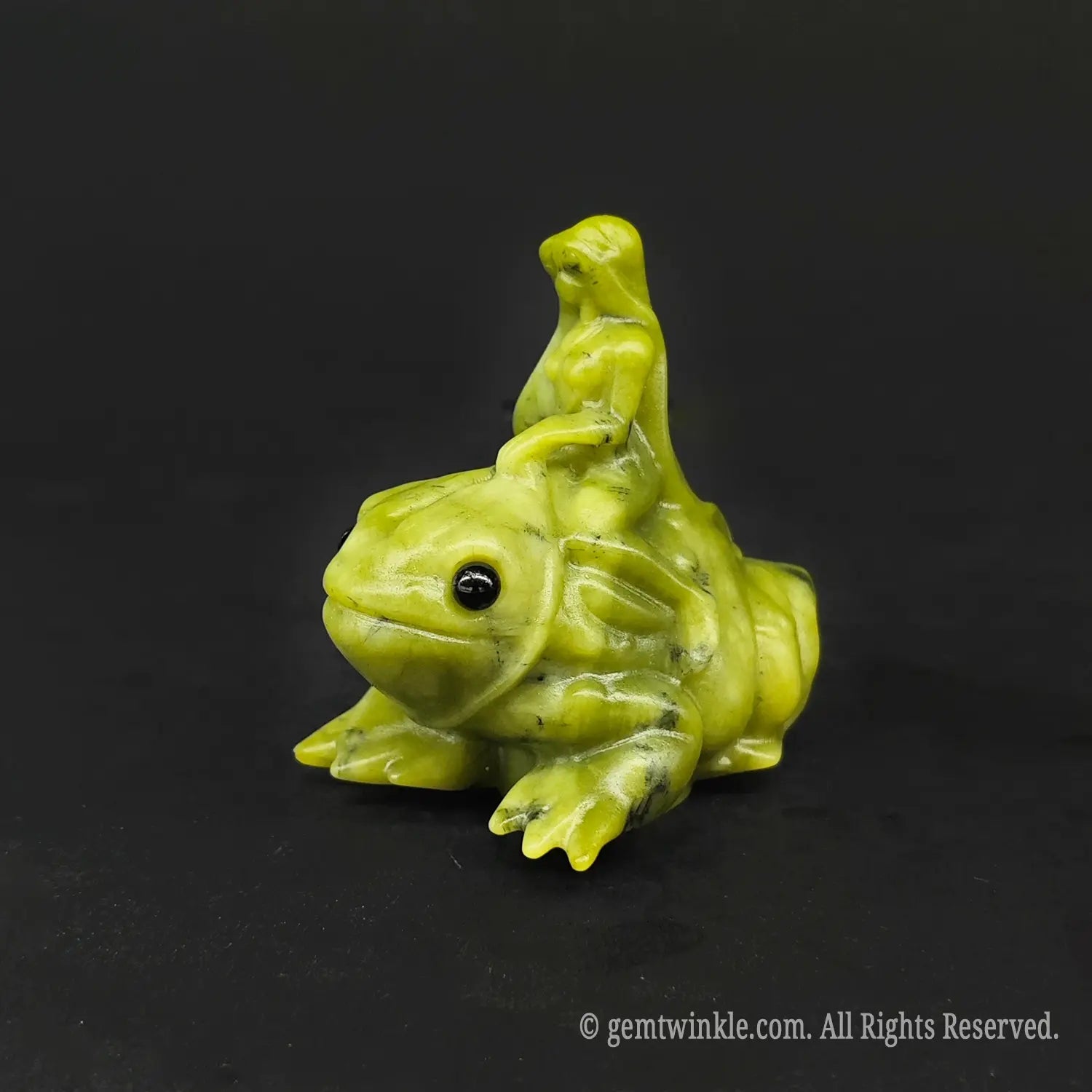 Angled front view of a whimsical serpentine stone fairy on toad carving displaying natural yellow green hues