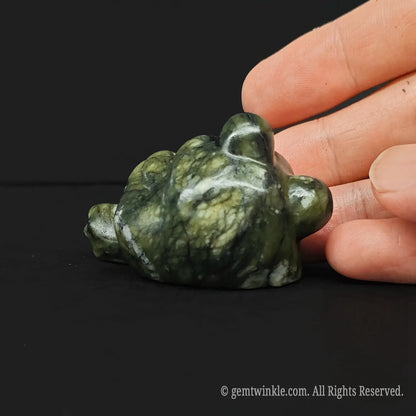 Top view of a whimsical serpentine stone lounging toad carving displaying its smooth polished green yellow mineral texture