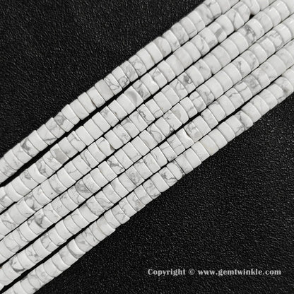 Angled view of white howlite flat disc gemstone strands arranged parallel on dark texture