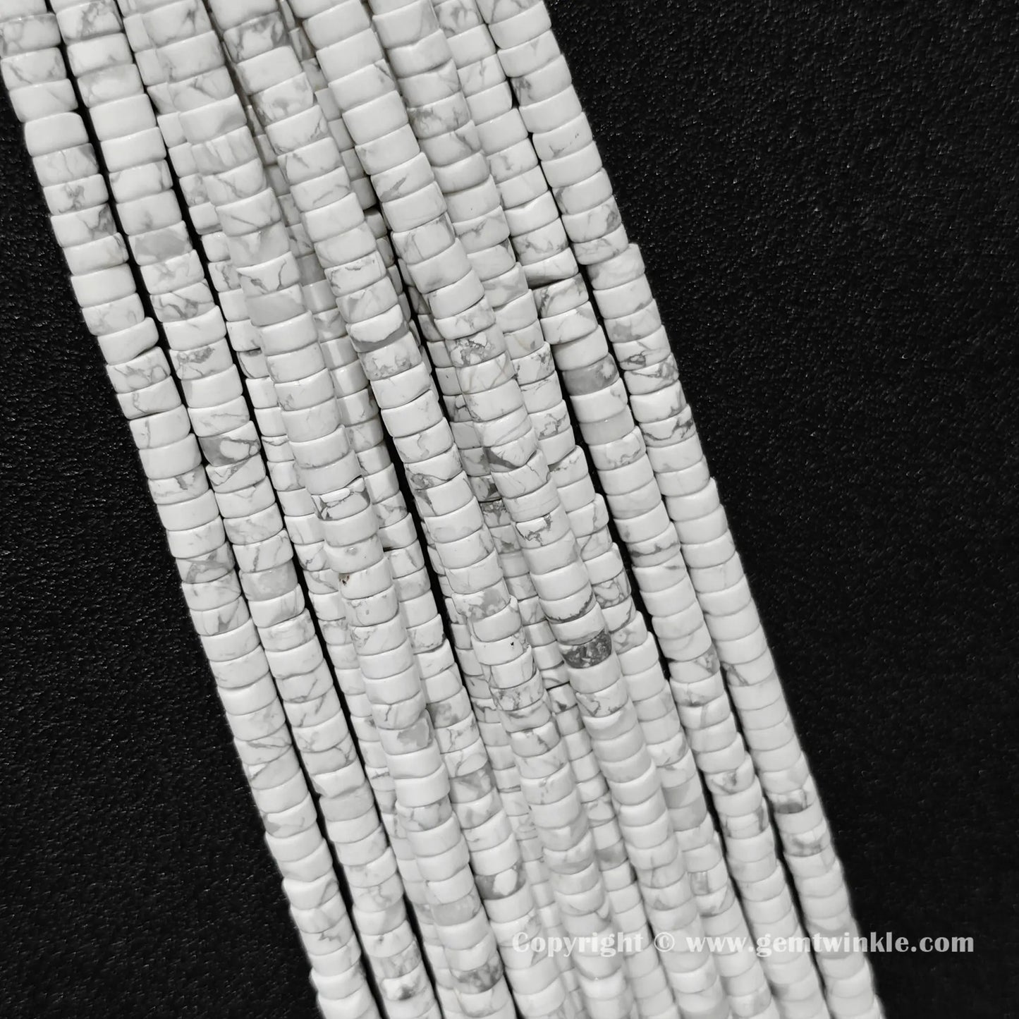 Multiple strands of natural white howlite disc rondelle beads laid together for bulk preview